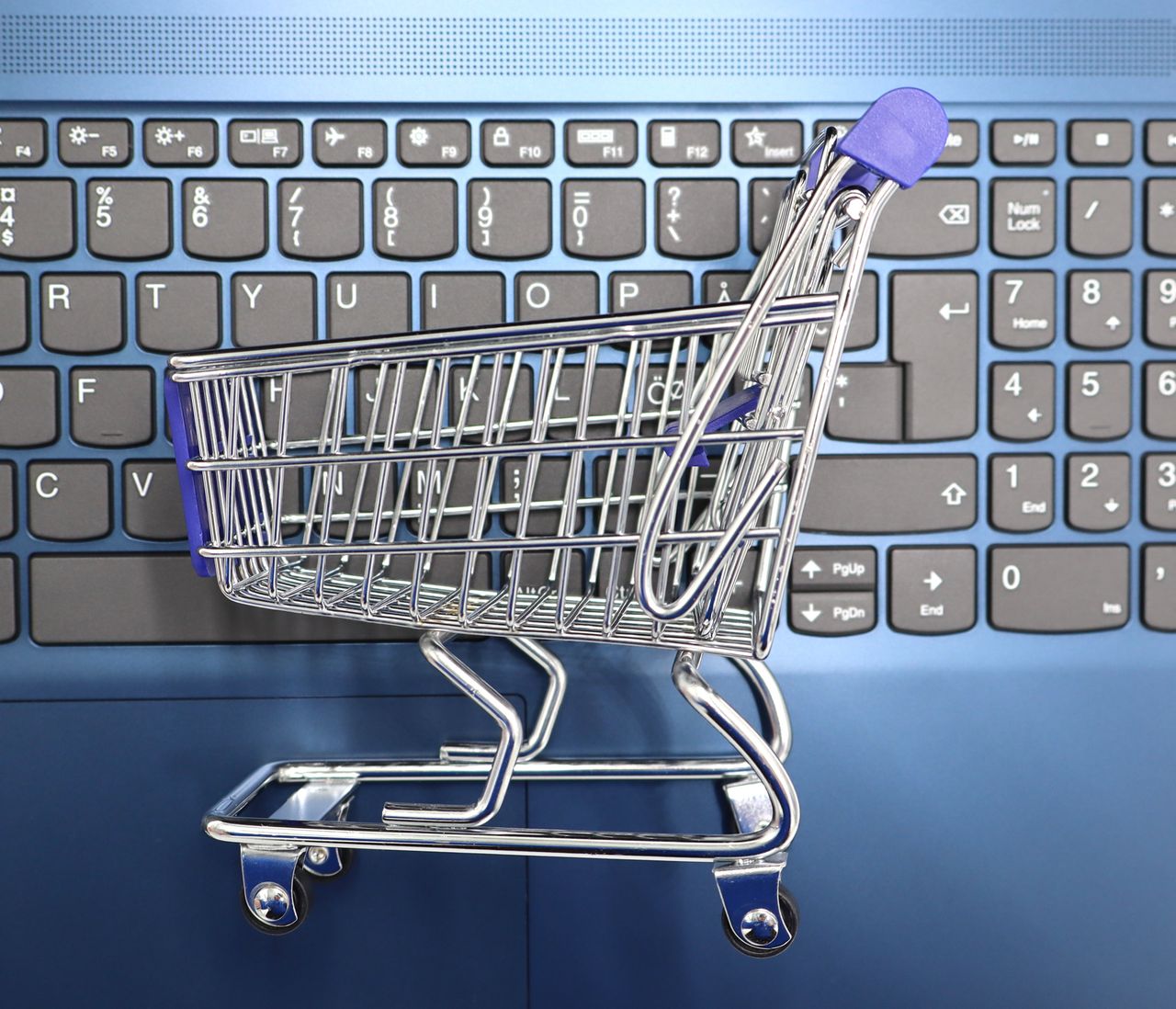 heros-img A miniature shopping cart placed on a laptop keyboard symbolizing online shopping and e-commerce.